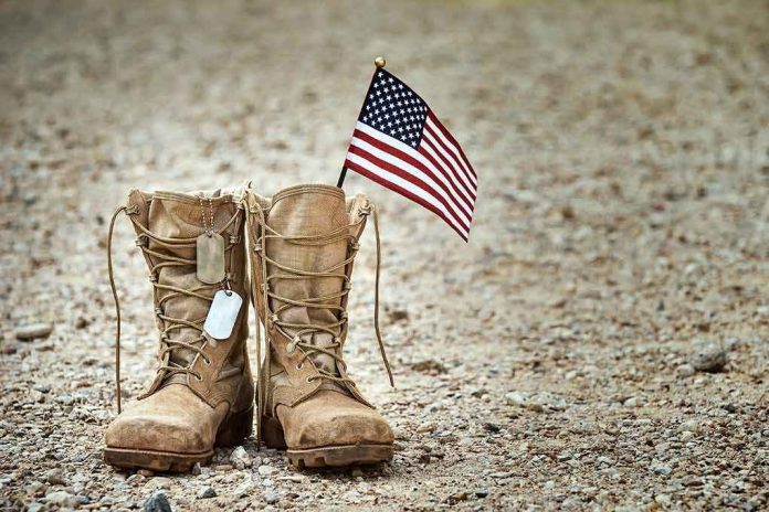 shutterstock_1392591209 Combat boots with dog tags and a small American flag on gravel