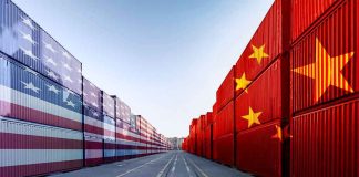 Shipping containers painted with US and China flags facing each other along a port lane