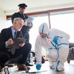 Forensic investigator collects evidence as police and detective observe