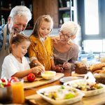 Your Kitchen Could Be Quietly Costing You $3K A Year Grandparents and two children cooking together in a bright kitchen