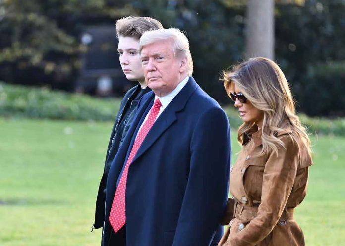 shutterstock_1572261610 Donald Trump and Melania Trump walking outdoors with another person