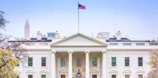 The White House facade with fountain and flag