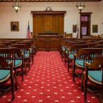 Cameras Stay In Charlie Kirk Murder Case Courtroom with wooden benches facing the judge's bench