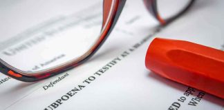 Subpoena document with red highlighter and eyeglasses