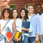 Group of students standing outdoors with notebooks