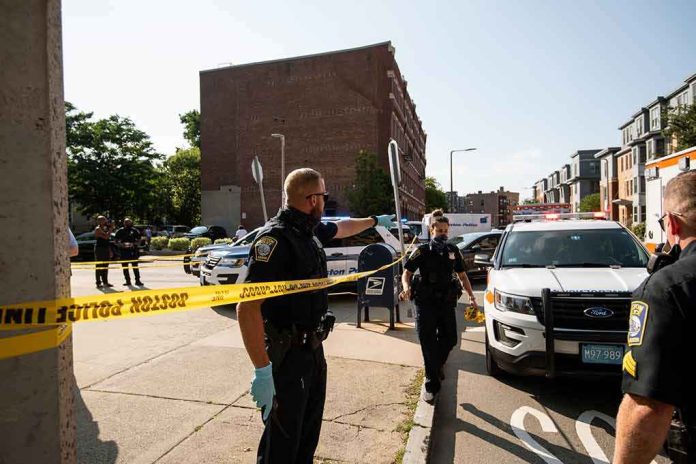 shutterstock_1781781026 Police officers secure an urban street with yellow tape near patrol cars