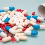 Assorted pills and capsules spilled from a bottle