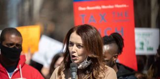 Woman speaking into a microphone at a rally