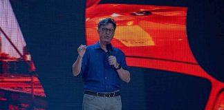 Stephen Colbert speaking on stage with a microphone