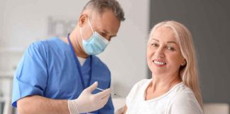 Smiling woman receiving a vaccination from a healthcare worker