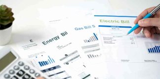 Hands reviewing utility bills with calculator and pen