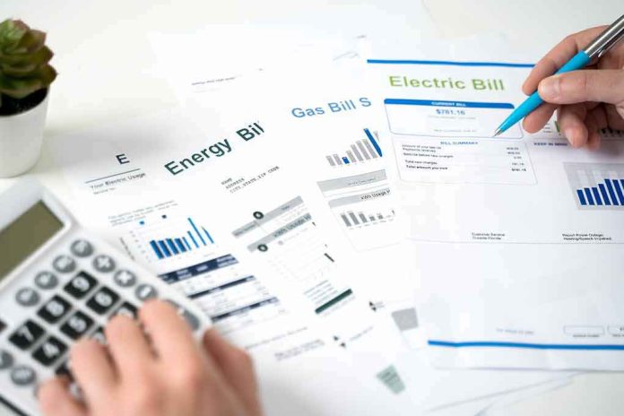 shutterstock_2050722521 Hands reviewing utility bills with calculator and pen