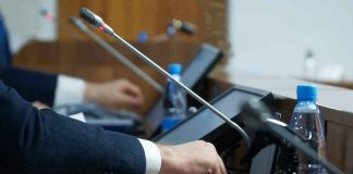Person pressing a button on a conference microphone panel