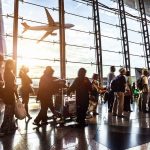 Embryo Smuggling SCANDAL: Arrest at Cyprus Airport Passengers queue inside an airport terminal at sunset