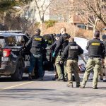 He Criticized Police, Then They Came Before Dawn Police and sheriff officers gather around vehicles on a suburban street