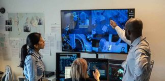 Security team monitors multiple surveillance screens in control room