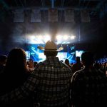 Child Predator Ties Haunt Tejano Star Cowboy-hatted man watches a concert in a packed arena