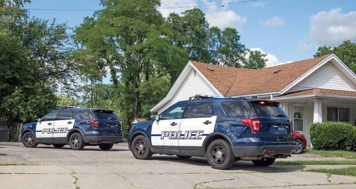 Two police SUVs parked near a suburban house