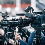 Obama’s Quiet Fauci Lifeline Exposed Broadcast cameras on tripods at a press event