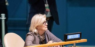 Woman seated at a United Nations desk with a United States nameplate