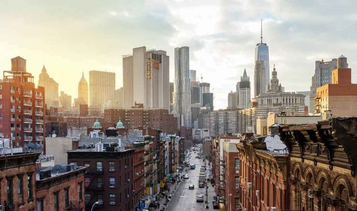 shutterstock_2274847249 City street leading to a skyline of modern and historic skyscrapers at sunset