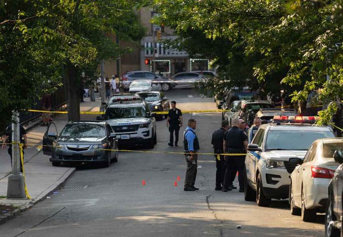 shutterstock_2330301305-3 Police officers secure a residential street with patrol cars and yellow tape