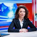 News anchor seated at a broadcast desk