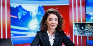 News anchor seated at a broadcast desk