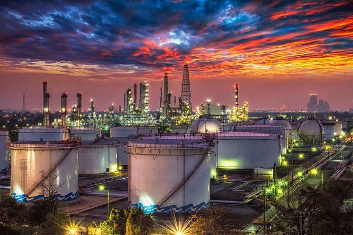 Oil refinery with storage tanks at sunset