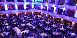 Ballroom filled with round tables at a formal gala dinner