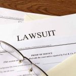 Legal documents labeled lawsuit on a desk