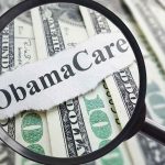 Magnifying glass over cash highlighting Obamacare text