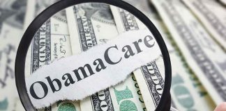 Magnifying glass over cash highlighting Obamacare text