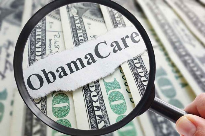 shutterstock_468939914 Magnifying glass over cash highlighting Obamacare text