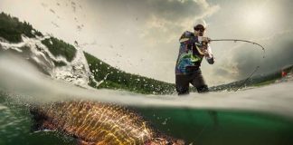angler fighting a large fish in a split-level water shot