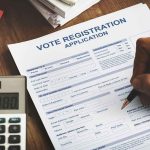 System Glitch Lets Ineligible Ballots Through Person filling out a voter registration application form
