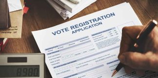 Person filling out a voter registration application form