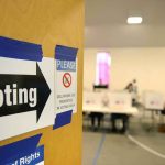 Jessica Tarlov Saying Dems Are on the Side of Sanity Voting sign on door leading to polling place