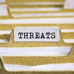 AI Panic Triggers Massive Pentagon Blackout index tab labeled threats in a filing organizer