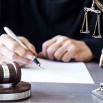 Lightning Verdict Shocks Texas Courtroom Judge writing at desk with gavel and Lady Justice statue