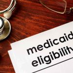 Ghost Hospices Milked $267M In Fraud Medicaid eligibility form with stethoscope and pen on desk