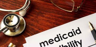 Medicaid eligibility form with stethoscope and pen on desk