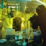 Rotting Food Mountain Chokes LA armed officer confronts people in hazmat suits inside a lab