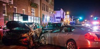 two cars collide on a city street at night