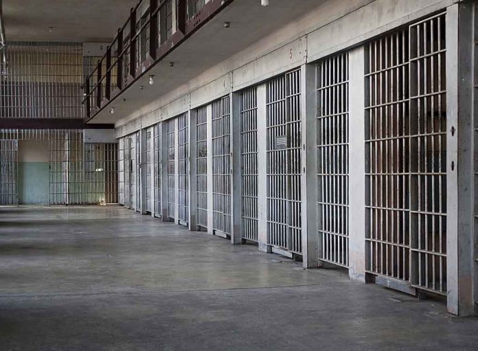 shutterstock_100994692-1 prison cell block with metal barred doors
