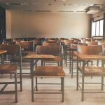 NYC School Staff Accused of SEXUAL Misconduct Empty classroom with rows of wooden desks and chairs