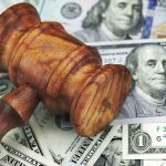 $5 MILLION Raise Plan Sparks Discrimination Fight Wooden judge's gavel on scattered US dollar bills