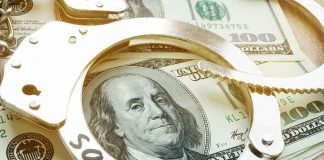 Handcuffs on U.S. hundred-dollar bills