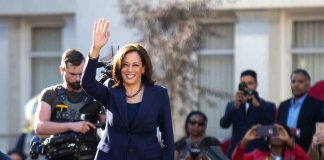 Kamala Harris waves to a crowd at an outdoor event