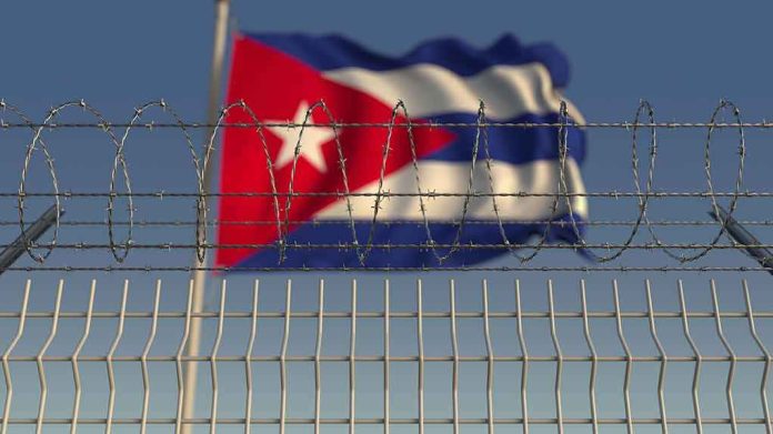 shutterstock_1331782661 Barbed wire fence with Cuban flag in the background